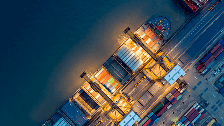 Birds eye view of a shipping container in port lit up at night