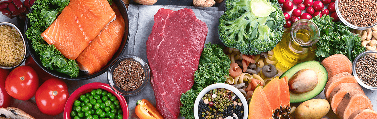food safety shown as a range of ingredients laid out on a table showing meat fish vegetables and fruit